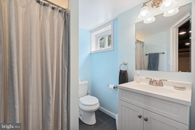 full bath with toilet, tile patterned flooring, vanity, and baseboards