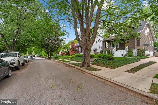 view of asphalt road featuring sidewalks and curbs