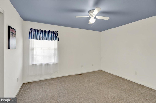 empty room featuring visible vents, ceiling fan, carpet, and baseboards