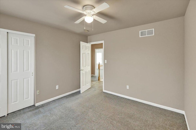unfurnished bedroom featuring carpet floors, visible vents, ceiling fan, and baseboards