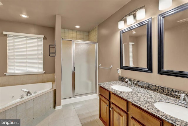 full bath featuring a tub with jets, tile patterned floors, a stall shower, and a sink