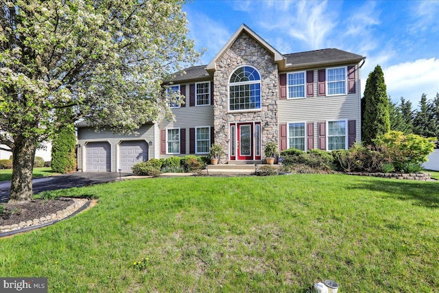 view of front of home featuring a front yard, driveway, and stone siding