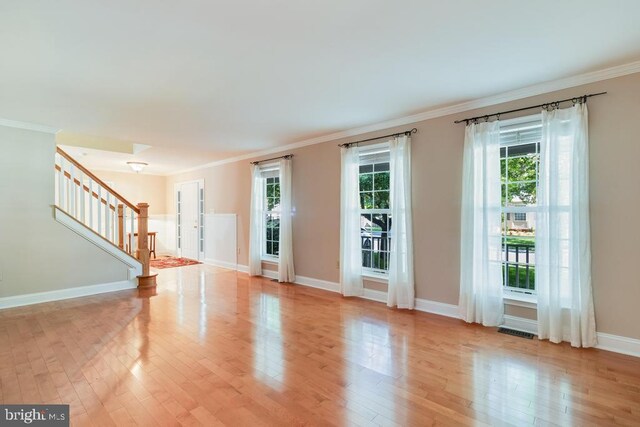 10995 Alcorn Ln, Waldorf, MD 20603 - unfurnished living room featuring stairway, light wood-type flooring, ornamental molding, and baseboards
