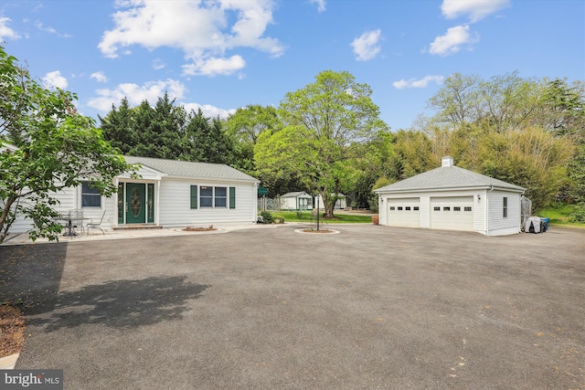 exterior space with a detached garage and an outdoor structure