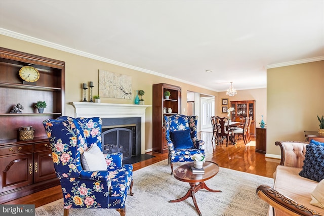 living area with an inviting chandelier, crown molding, and wood finished floors