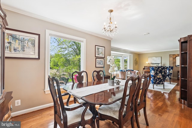 dining area with crown molding, baseboards, wood finished floors, and a chandelier