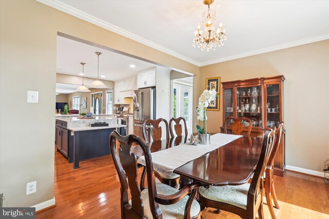 dining room with baseboards, a wealth of natural light, wood finished floors, and a notable chandelier