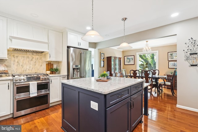 kitchen with backsplash, appliances with stainless steel finishes, light wood-type flooring, white cabinets, and recessed lighting
