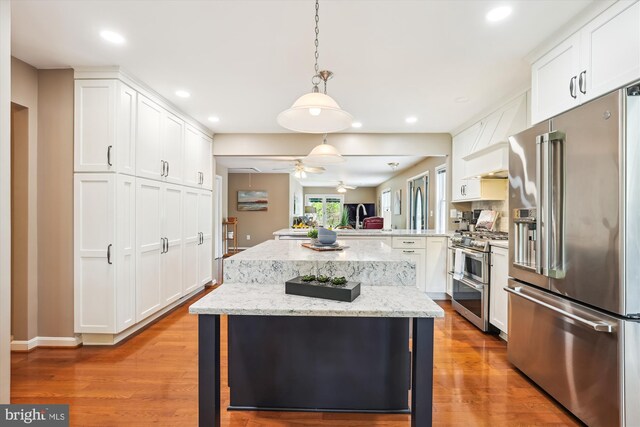 kitchen featuring a kitchen island, stainless steel appliances, recessed lighting, and white cabinets