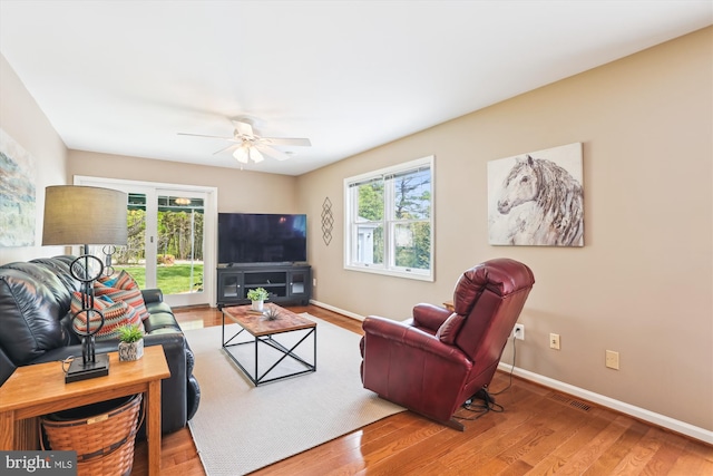 living room with a ceiling fan, baseboards, a healthy amount of sunlight, and wood finished floors