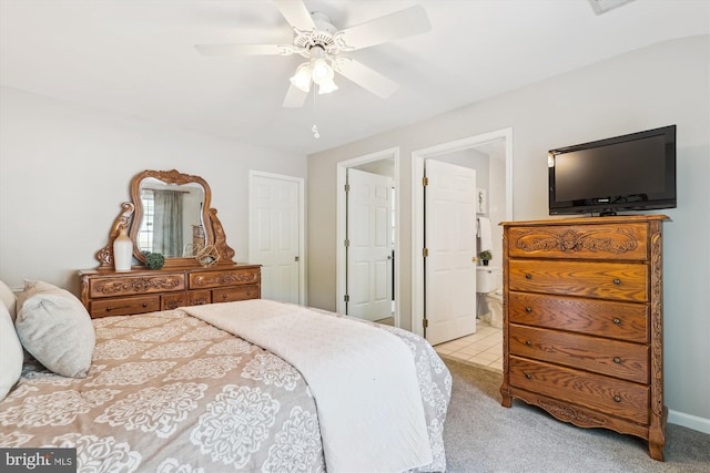 bedroom with light colored carpet, ceiling fan, and ensuite bathroom