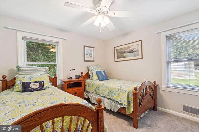 carpeted bedroom featuring a ceiling fan, baseboards, and visible vents