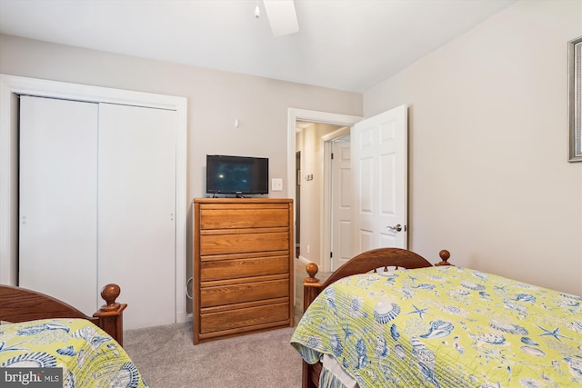 bedroom with light colored carpet, a ceiling fan, and a closet