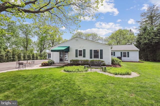 ranch-style house with driveway and a front yard