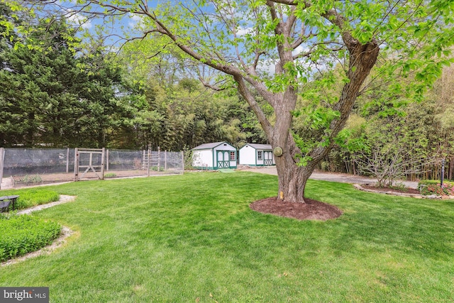 view of yard with fence, an outdoor structure, and a shed