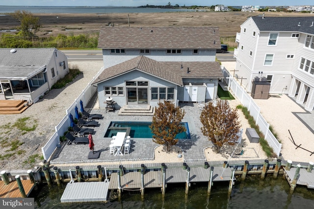 back of house with a fenced backyard, a water view, and a patio area