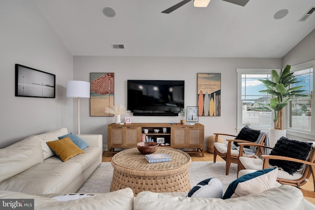 living area with vaulted ceiling, a ceiling fan, and wood finished floors