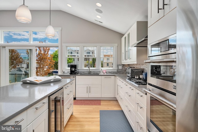 kitchen featuring beverage cooler, recessed lighting, light wood-style flooring, white cabinetry, and stainless steel appliances