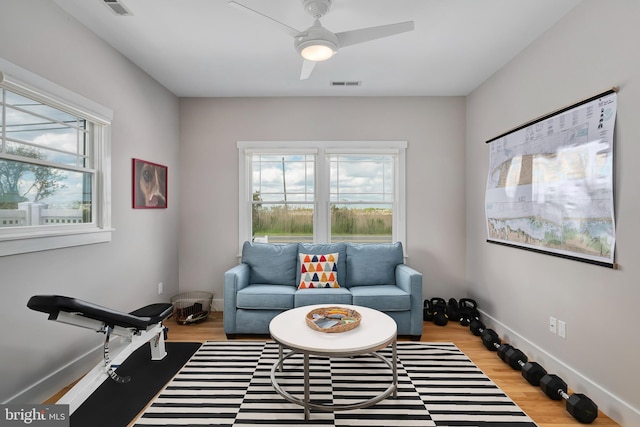 sitting room featuring wood finished floors, a ceiling fan, and baseboards