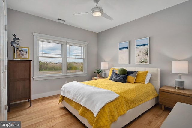 bedroom featuring wood finished floors, baseboards, and a ceiling fan