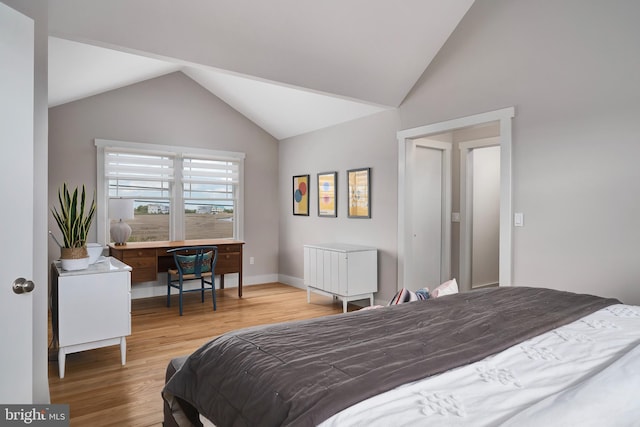 bedroom with lofted ceiling, wood finished floors, and baseboards