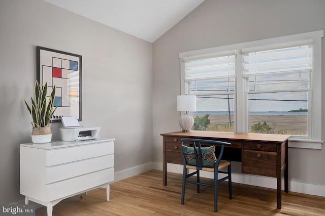office space featuring lofted ceiling, light wood-style flooring, and baseboards