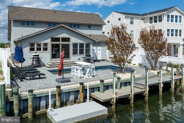 rear view of house featuring entry steps, a water view, a patio area, and a fenced backyard