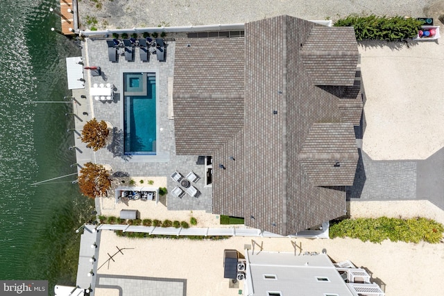 view from above of property with a nearby body of water and a pool area