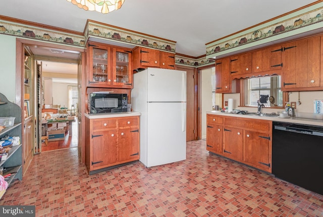 kitchen featuring black appliances, a sink, light countertops, and brown cabinets