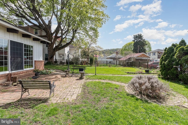 view of yard featuring fence, a residential view, and a patio area