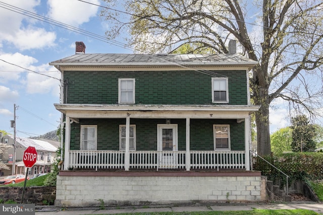 view of front of property featuring a chimney and covered porch