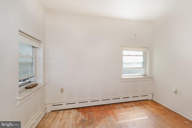 spare room with light wood-type flooring and a baseboard heating unit