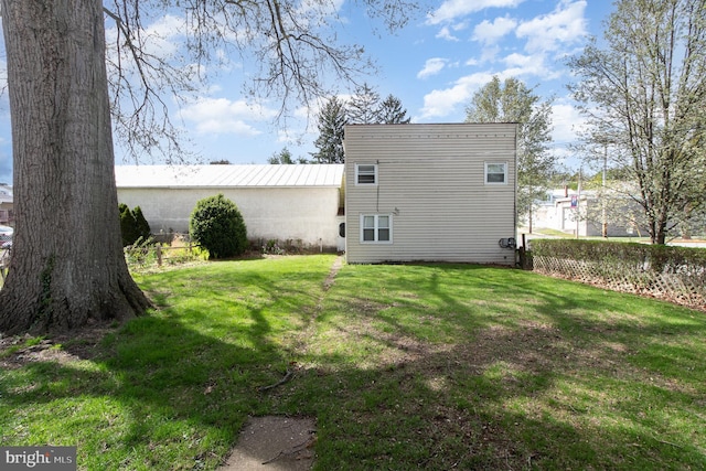 back of house featuring a lawn and fence