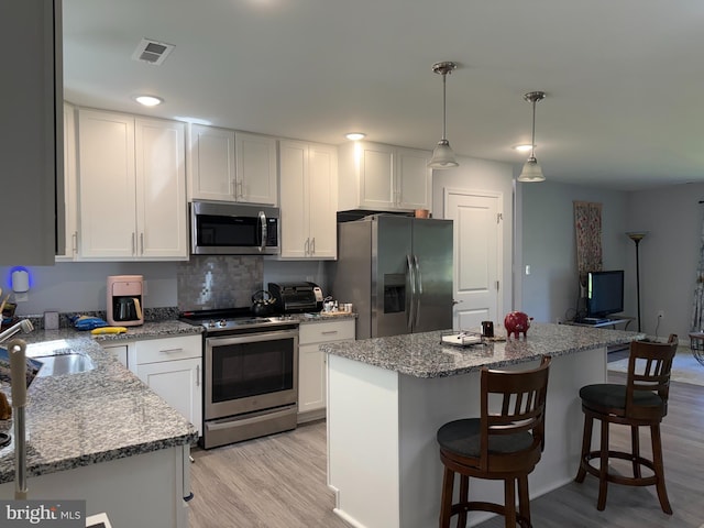 14273 Brandy Ln, Georgetown, DE 19947 - kitchen featuring appliances with stainless steel finishes, white cabinets, light wood-type flooring, and a sink