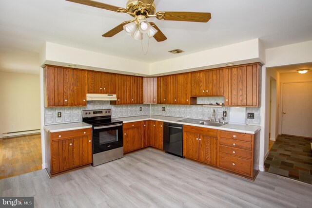 2500 Eberhart Rd, Quakertown, PA 18951 - kitchen with a baseboard radiator, black dishwasher, under cabinet range hood, stainless steel electric stove, and a sink