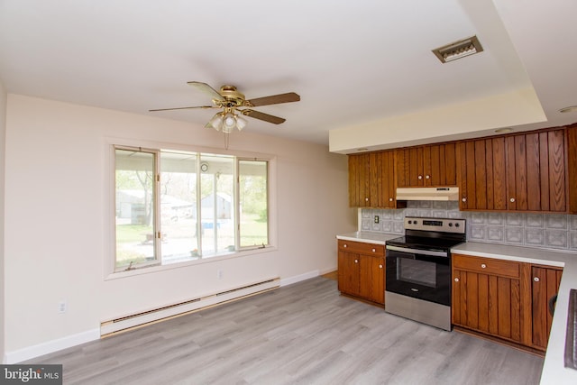2500 Eberhart Rd, Quakertown, PA 18951 - kitchen with baseboard heating, brown cabinets, stainless steel range with electric cooktop, light countertops, and under cabinet range hood