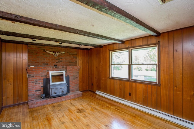 2500 Eberhart Rd, Quakertown, PA 18951 - unfurnished living room with a textured ceiling, beam ceiling, a baseboard heating unit, wooden walls, and light wood-style flooring