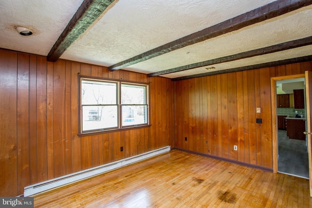 2500 Eberhart Rd, Quakertown, PA 18951 - empty room with a baseboard radiator, beam ceiling, wooden walls, and hardwood / wood-style floors