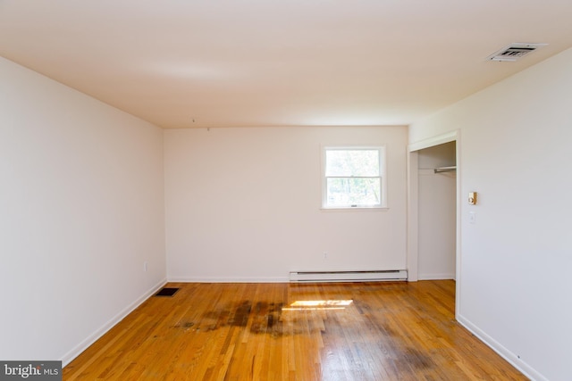 2500 Eberhart Rd, Quakertown, PA 18951 - unfurnished room featuring baseboards, visible vents, hardwood / wood-style floors, and a baseboard radiator