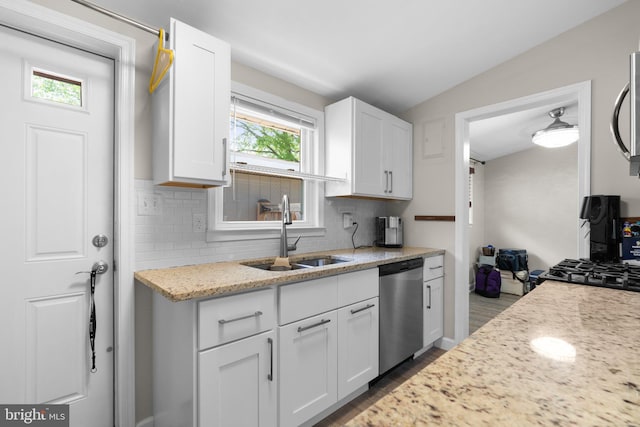 kitchen featuring a sink, appliances with stainless steel finishes, decorative backsplash, and white cabinets