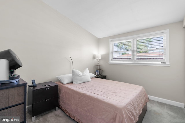 carpeted bedroom featuring baseboards and vaulted ceiling