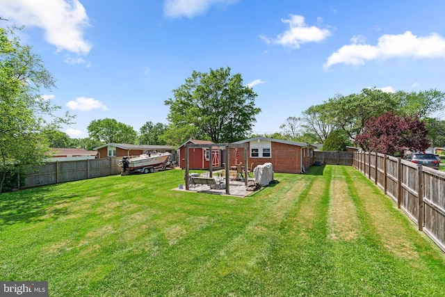 view of yard featuring a fenced backyard, a shed, and an outbuilding