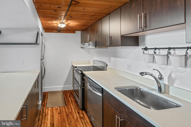 kitchen with a sink, light countertops, stainless steel appliances, dark wood-type flooring, and wood ceiling