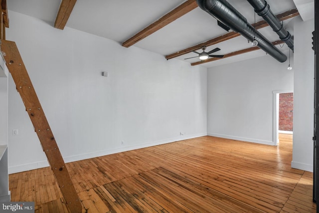 spare room featuring baseboards, ceiling fan, hardwood / wood-style floors, and beamed ceiling