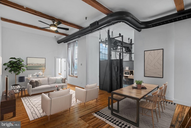 living room with a ceiling fan, baseboards, beam ceiling, and wood finished floors