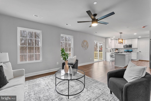 6955 Solomons Island Rd N, Sunderland, MD 20689 - living area featuring visible vents, wood finished floors, and baseboards