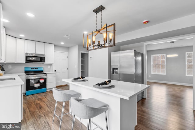 6955 Solomons Island Rd N, Sunderland, MD 20689 - kitchen featuring white cabinets, appliances with stainless steel finishes, light countertops, a kitchen island, and dark wood-style flooring