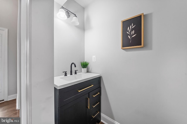 6955 Solomons Island Rd N, Sunderland, MD 20689 - bathroom featuring wood finished floors, vanity, and baseboards