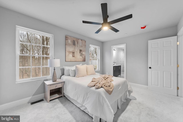 6955 Solomons Island Rd N, Sunderland, MD 20689 - bedroom featuring light colored carpet, visible vents, ensuite bathroom, baseboards, and a ceiling fan