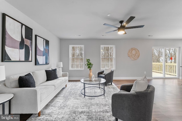 6955 Solomons Island Rd N, Sunderland, MD 20689 - living area featuring wood finished floors, a healthy amount of sunlight, a ceiling fan, and baseboards